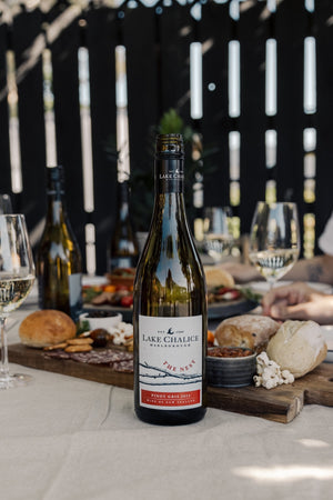 Lake Chalice wine bottle on a table with food and glasses in the background